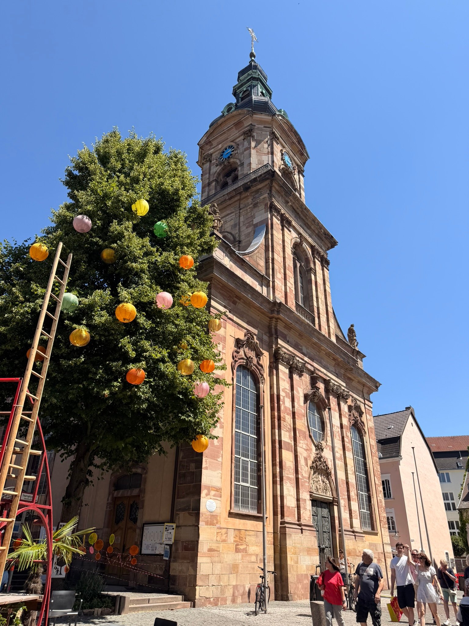 A tree in front of a church steeple in Saarbrücken